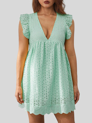 a woman wearing a green dress with a cut out back