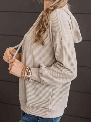 a woman wearing a tan sweater and jeans