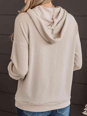 a woman wearing a beige sweater and jeans