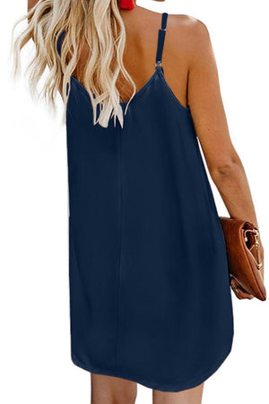 a woman wearing a blue dress with a halter neckline