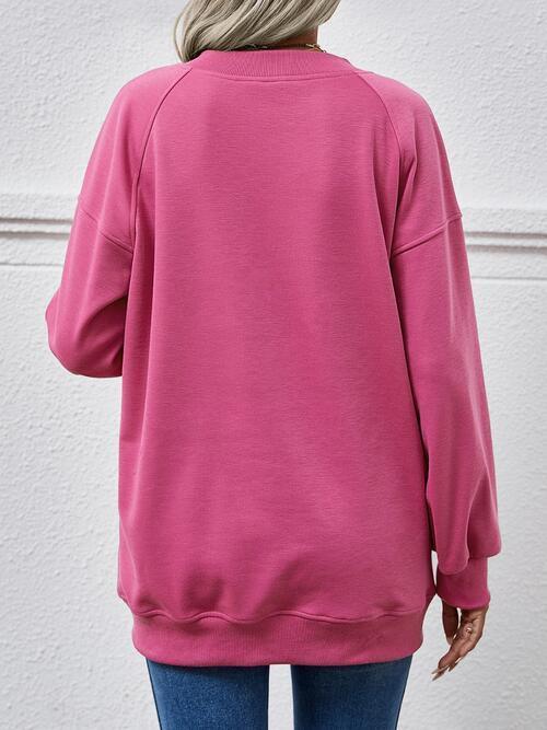 a woman wearing a pink sweatshirt and jeans