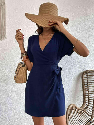 a woman wearing a blue dress and a straw hat