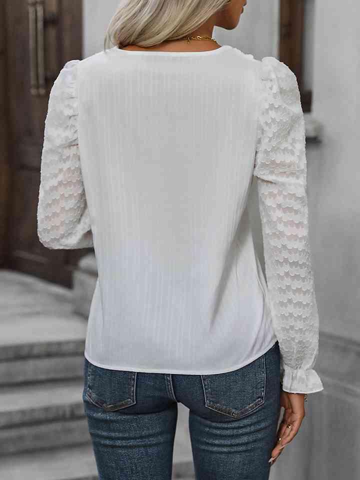 a woman wearing a white blouse and jeans