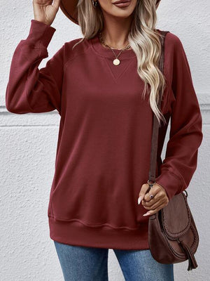 a woman wearing a burgundy sweater and jeans