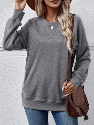 a woman wearing a gray sweatshirt and jeans