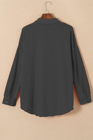 a black shirt hanging on a wooden hanger