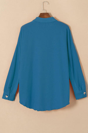 a blue shirt hanging on a wooden hanger