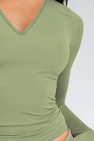 a woman in a green top with her hands on her hips