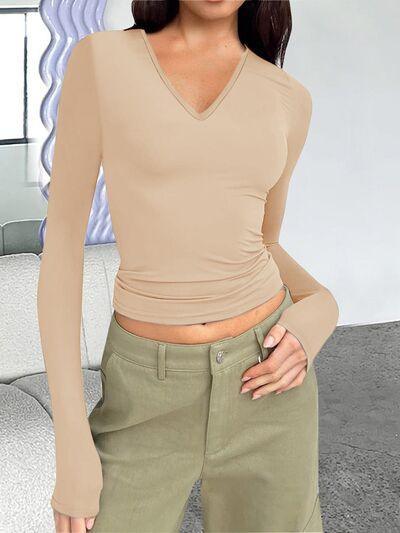 a woman wearing a tan top and khaki pants