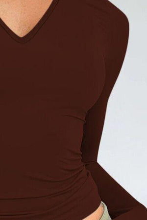 a woman wearing a brown shirt and tan pants