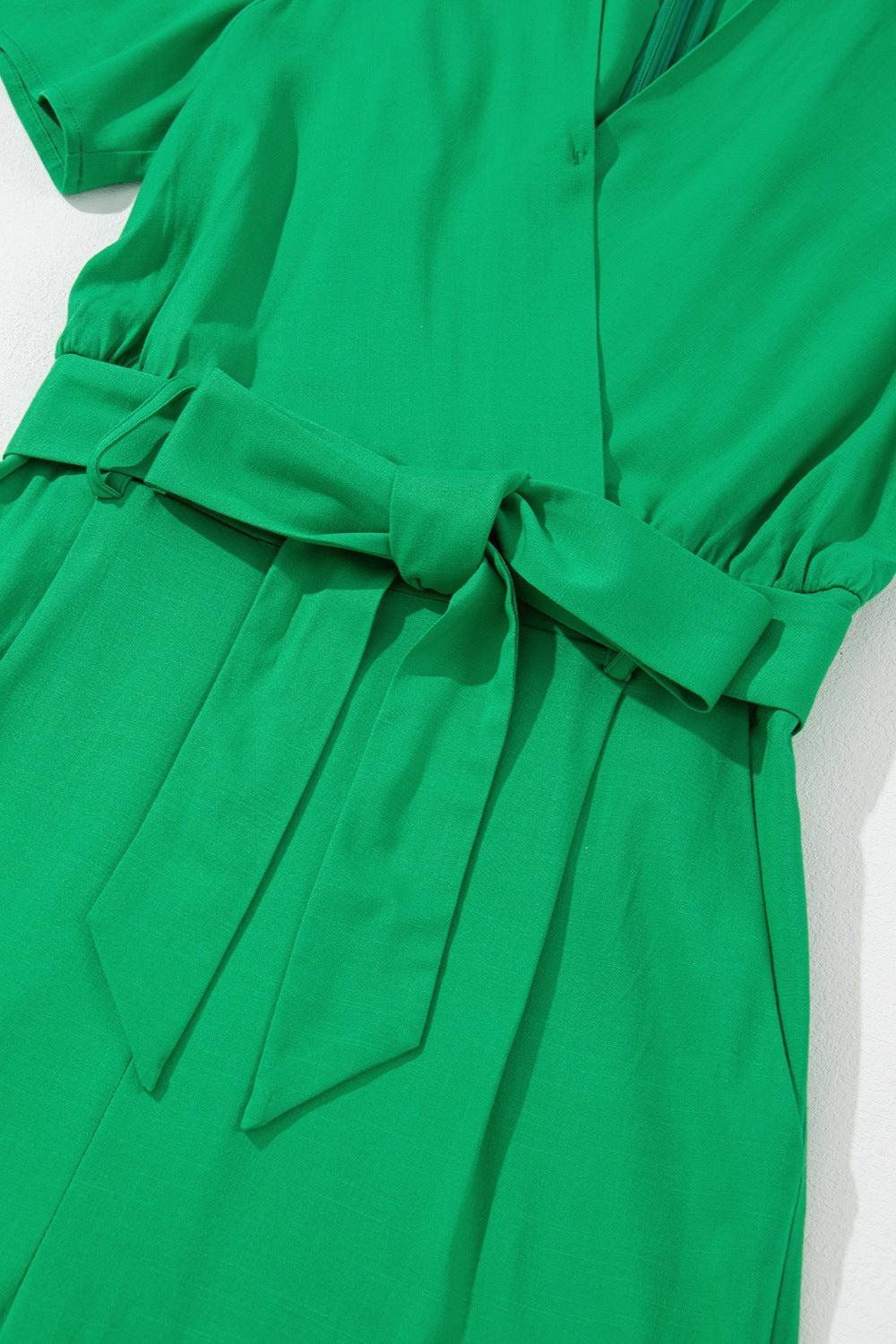 a green dress with a bow at the waist