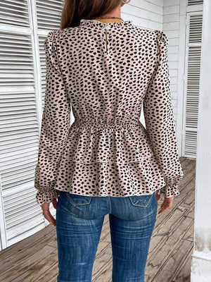 a woman standing on a porch wearing a leopard print top
