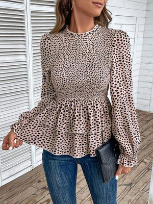 a woman wearing a leopard print blouse and jeans