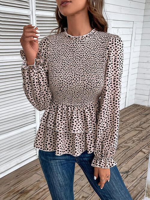 a woman wearing a leopard print blouse and jeans