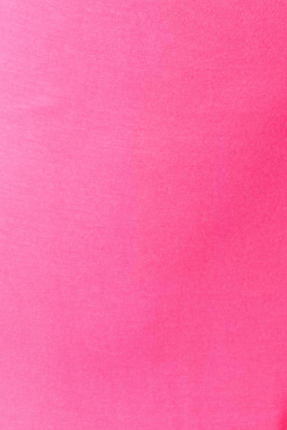 a woman in a pink shirt holding a cell phone