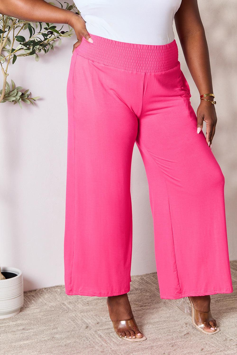a woman in a white top and pink pants