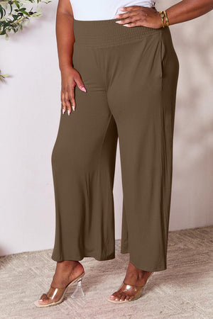a woman in a white top and brown pants