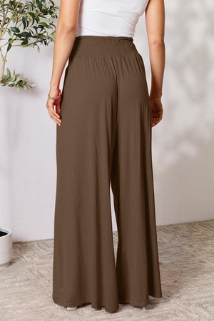 a woman in a white top and brown pants