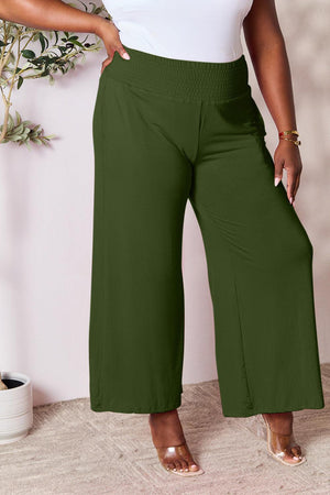 a woman in a white top and green pants