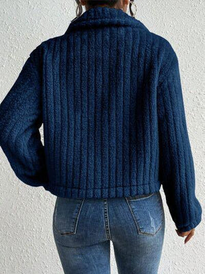 a woman wearing a blue sweater and jeans