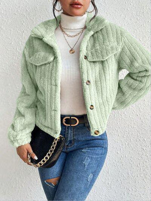 a woman wearing a green jacket and jeans