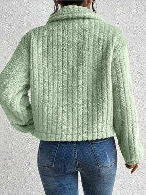a woman wearing a green sweater and jeans
