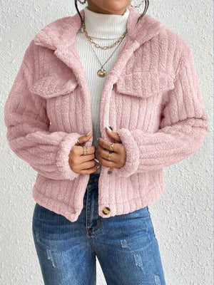 a woman wearing a pink jacket and jeans