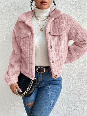 a woman wearing a pink jacket and jeans