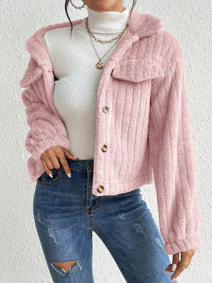 a woman wearing a pink jacket and ripped jeans