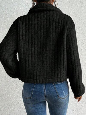 a woman wearing a black sweater and jeans