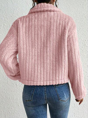 a woman wearing a pink sweater and jeans