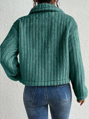 a woman wearing a green sweater and jeans