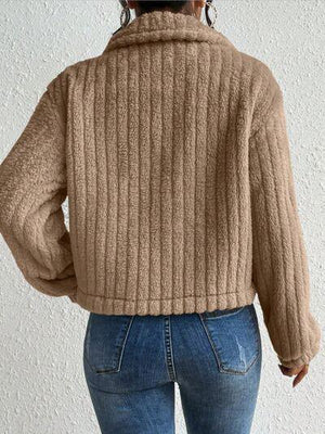 a woman wearing a brown sweater and jeans