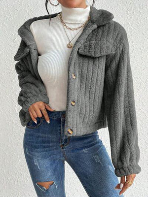 a woman wearing a gray jacket and ripped jeans