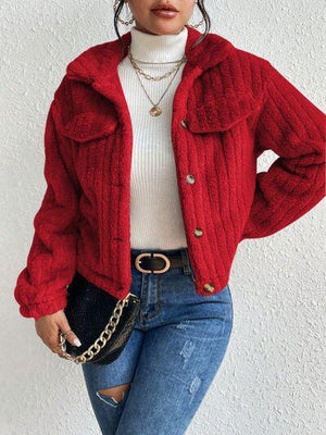 a woman wearing a red jacket and jeans