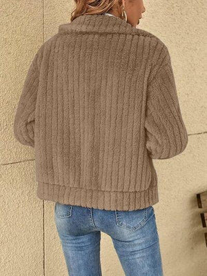 a woman wearing a brown sweater and jeans