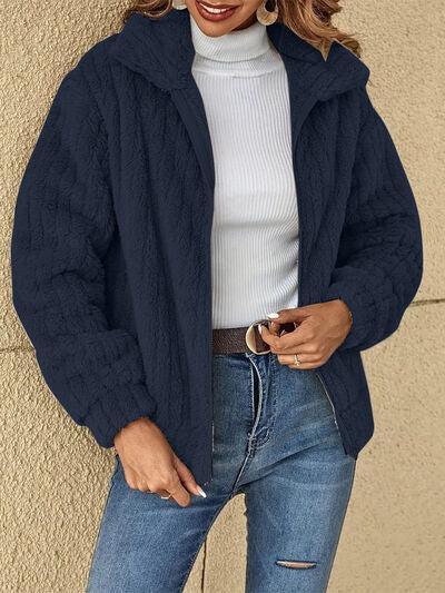 a woman wearing a blue jacket and jeans