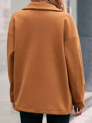 a woman in a brown coat is walking down the street