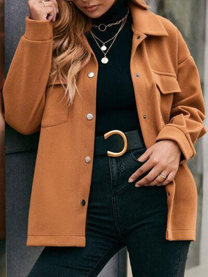 a woman wearing a brown coat and black pants