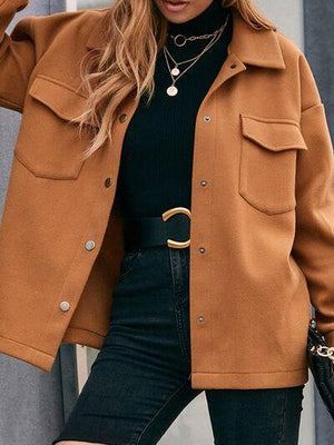 a woman wearing a brown jacket and black top