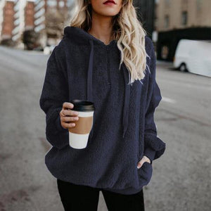 a woman in a blue hoodie holding a cup of coffee