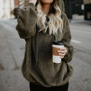 a woman in a fuzzy hoodie holding a cup of coffee