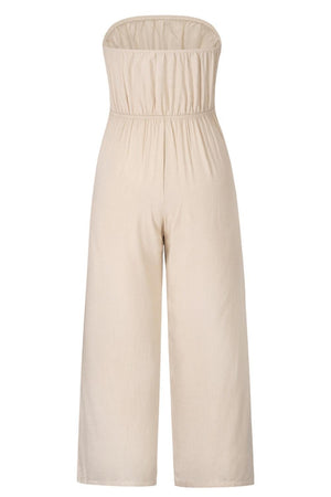 a woman is wearing a beige jumpsuit