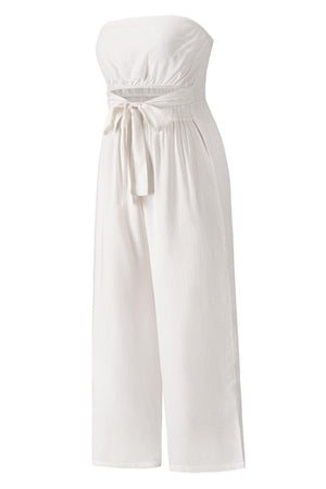 a woman wearing a white jumpsuit with a tie around the waist