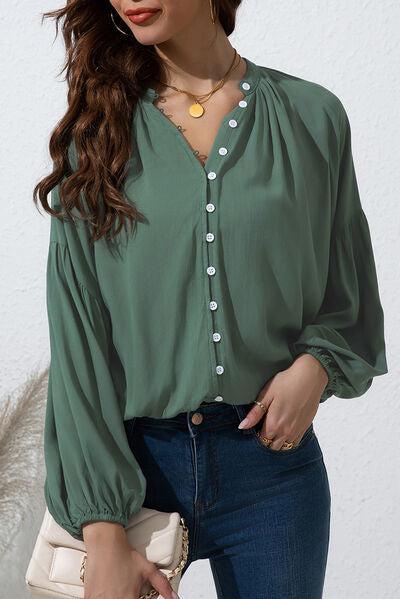 a woman wearing a green blouse and jeans
