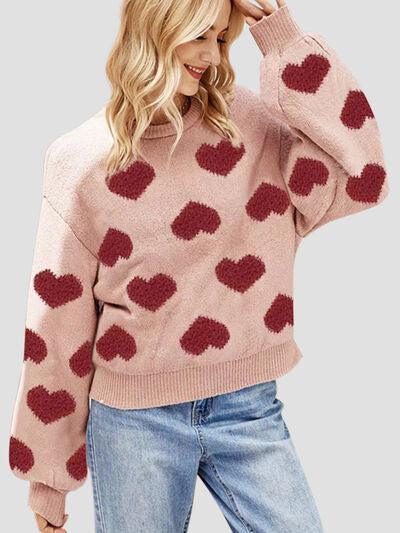 a woman wearing a pink sweater with red hearts on it