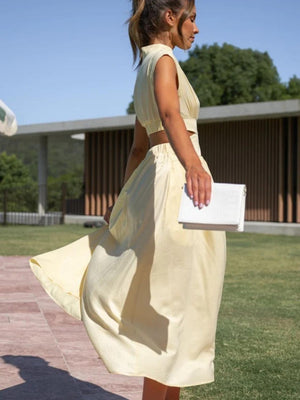 a woman in a yellow dress walking across a field