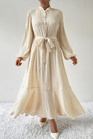 a woman in a white dress standing on a white rug