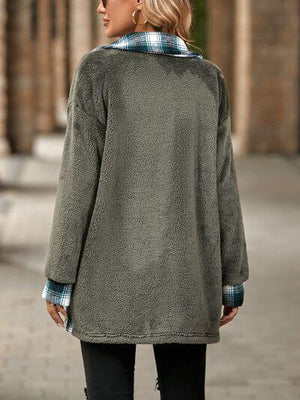 a woman wearing a green coat and black pants