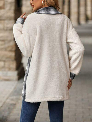 a woman wearing a white coat and jeans